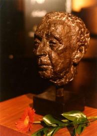 Portada:Primer plano de un busto en bronce de Arthur Rubinstein, sobre una mesa junto a una margarita naranja