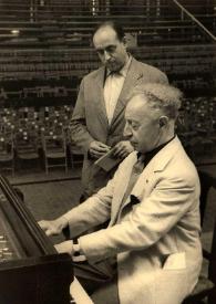 Portada:Plano medio de Arthur Rubinstein (perfil izquierdo) sentado al piano, detrás un hombre le observa