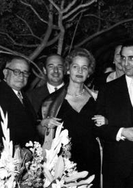 Portada:Plano general de Arthur Rubinstein, fumando, y  Aniela Rubinstein posando con otras personas