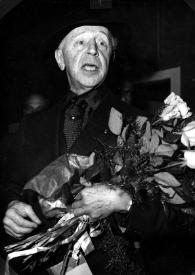 Portada:Plano medio de Arthur Rubinstein con un ramo de flores entre los brazos