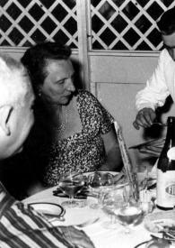 Portada:Plano medio de Vladimir Golschmann, Olga de Cadaval, Arthur Rubinstein y Odette Golschmann sentados a la mesa. Un camarero sirviendo a Olga de Cadaval