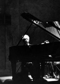 Portada:Plano general de Arthur Rubinstein sentado al piano y el director de orquesta (perfil derecho), con la batuta en la mano derecha, al fondo del escenario, la orquesta