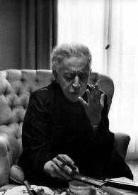 Portada:Plano medio de Arthur Rubinstein sentado con un puro en su mano derecha, en bata
