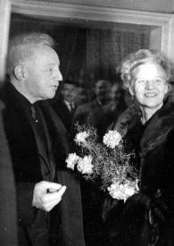 Portada:Plano general de Arthur Rubinstein (perfil derecho) y Aniela Rubinstein con un ramo de flores en las manos posando