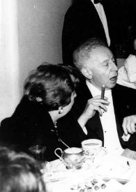 Portada:Plano medio de Arthur Rubinstein, fumando un puro charlando con Harry Neuhaus, Ewa Bandrowska y Henryk Sztompka