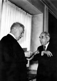 Portada:Plano general de Arthur Rubinstein (perfil derecho) charlando con Zbigniew Drzewiecki (perfil izquierdo)