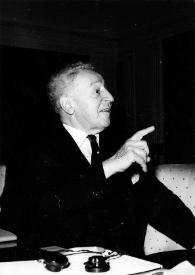 Portada:Plano medio de Arthur Rubinstein (perfil derecho) sentado, señalando con el dedo índice de la mano derecha