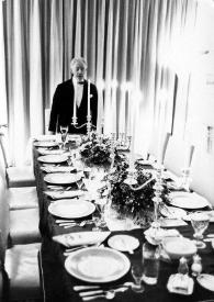 Portada:Plano medio de Arthur Rubinstein, de pie, posando junto a la meas preparada para la cena de Nochebuena