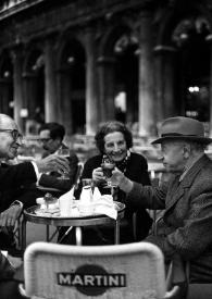 Portada:Plano general de George Szell, Helene Szell y Arthur Rubinstein brindando sentados en la terraza de una cafetería