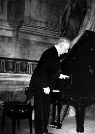 Portada:Plano general de Arthur Rubinstein (perfil derecho) saludando al público, de pie junto al piano