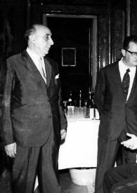 Portada:Plano general de Arthur Rubinstein (perfil izquierdo), sentado, conversando con tres hombres