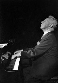 Portada:Plano general de Arthur Rubinstein (perfil izquierdo) sentado al piano, mirando hacia arriba