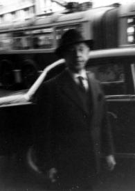 Portada:Plano medio de Arthur Rubinstein con sombrero, posando delante de un coche. Fotografía borrosa.