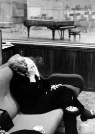 Portada:Plano general de Arthur Rubinstein (perfil derecho), sentado en un sillón, fumando un puro, escuchando las grabaciones
