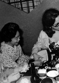 Portada:Plano medio de dos mujeres enseñando a Alina Rubinstein a tocar un instrumento típico japonés.