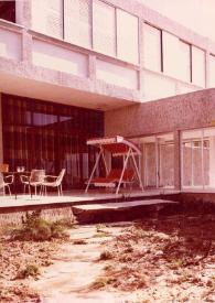 Portada:Plano general del porche y el patio de la Suite Rubinstein con una hamaca y sillas de terraza y una palmera.