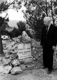 Portada:Plano general de Arthur Rubinstein (medio perfil izquierdo) observando la placa conmemorativa entre las rocas