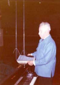 Portada:Plano medio de Arthur Rubinstein (perfil izquierdo) de pie junto al piano con unas partituras en las manos