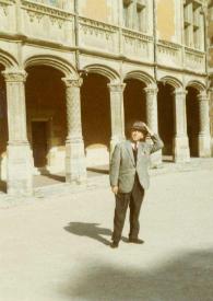 Portada:Plano general de Arthur Rubinstein posando en un rincón del palacio con unos pasadizos con arcos