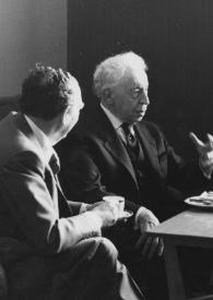 Portada:Plano medio de Arthur Rubinstein (perfil derecho) posando entre dos hombres sentados alrededor de una mesita de café