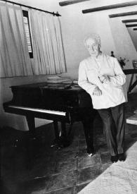 Portada:Plano general del estudio: Arthur Rubinstein, de pie, apoyado en el piano fumando un puro.