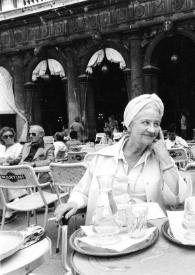 Portada:Plano medio de Aniela Rubinstein y Olga de Cadaval sentadas en la mesa de una terraza en una cafetería de la Plaza de San Marco, charlando