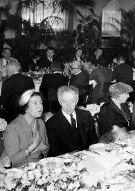 Portada:Plano general de una de las mesas de la comida: Arthur Rubinstein sentado junto a otras personas posando
