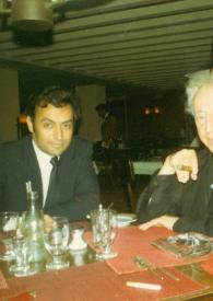 Portada:Plano medio de Arthur Rubinstein y Zubin Mehta sentados en la mesa de un restaurante posando