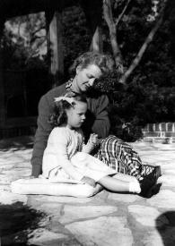Portada:Plano general de Alina sentada en el suelo sobre un cojín y Aniela Rubinstein a su lado observándole