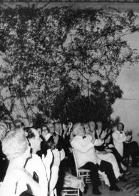 Portada:Plano general de Arthur Rubinstein (perfil derecho) saludando al público desde el escenario. Entre el público Aniela Rubinstein