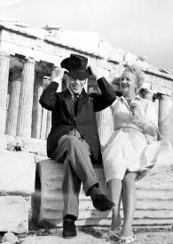 Portada:Plano general de Arthur Rubinstein sujetándose el sombrero y Aniela Rubinstein sentados en una columna en ruinas posando