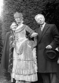 Portada:Plano general de Mimi Pecci Blunt y Arthur Rubinstein posando a ambos lados de una estatua de una mujer