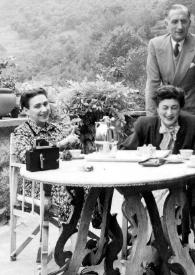 Portada:Plano general de una mujer, Wally Toscanini Castelbarco de pie, Marcia Davenport, un hombre y Arthur Rubinstein sentados en una mesa posando