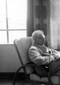 Portada:Plano general de Arthur Rubinstein (perfil derecho) sentado en una butaca