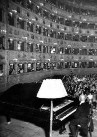 Portada:Plano general de la sala tomada desde el escenario, Arthur Rubinstein sentado al piano, al fondo el público