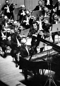 Portada:Plano general de la orquesta, en el centro Arthur Rubinstein sentado al piano y Eugène Ormandy dirigiendo la orquesta
