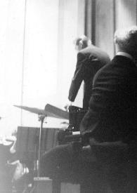 Portada:Plano general de Arthur Rubinstein de espaldas sentado al piano, al fondo el director de la orquesta