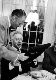 Portada:Plano medio de George R. Marek entregándole el premio a Arthur Rubinstein que está sentado en una mesa en compañía de Lawrence W. Kanaga