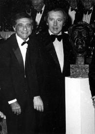 Portada:Plano general de dos hombres, John Rubinstein con bigote, Zubin Mehta y Fredric Rand Mann posando junto al busto de Arthur Rubinstein