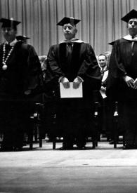 Portada:Plano general de Arthur Rubinstein de pie junto a un hombre, Jascha Heifetz  (sin sombrero)  y otros doctorados posando