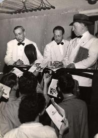 Portada:Plano general Gregor Piatigorsky, Jascha Heifetz y Arthur Rubinstein firmando autógrafos