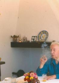 Portada:Plano medio de Arthur Rubinstein sentado en una mesa y con un puro
