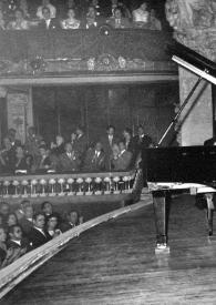 Portada:Plano general de Arthur Rubinstein sentado al piano, al fondo el público aplaudiendo. A Arthur se le ve entre la base del piano y la tapa