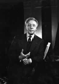 Portada:Plano general de Arthur Rubinstein, de pie, posando con el brazo derecho apoyado en el piano